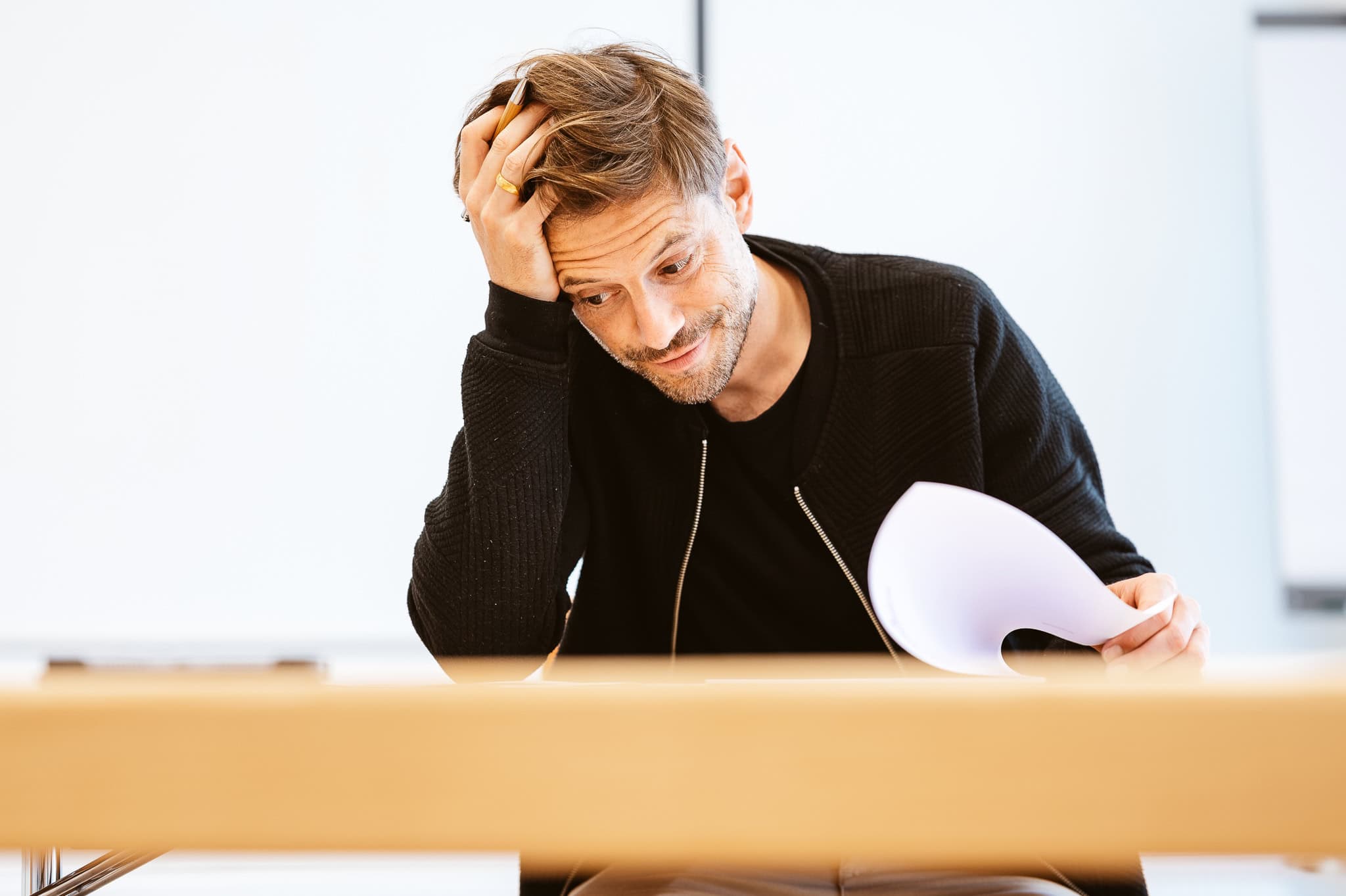 Junger Mann füllt haarraufend einen Antrag aus